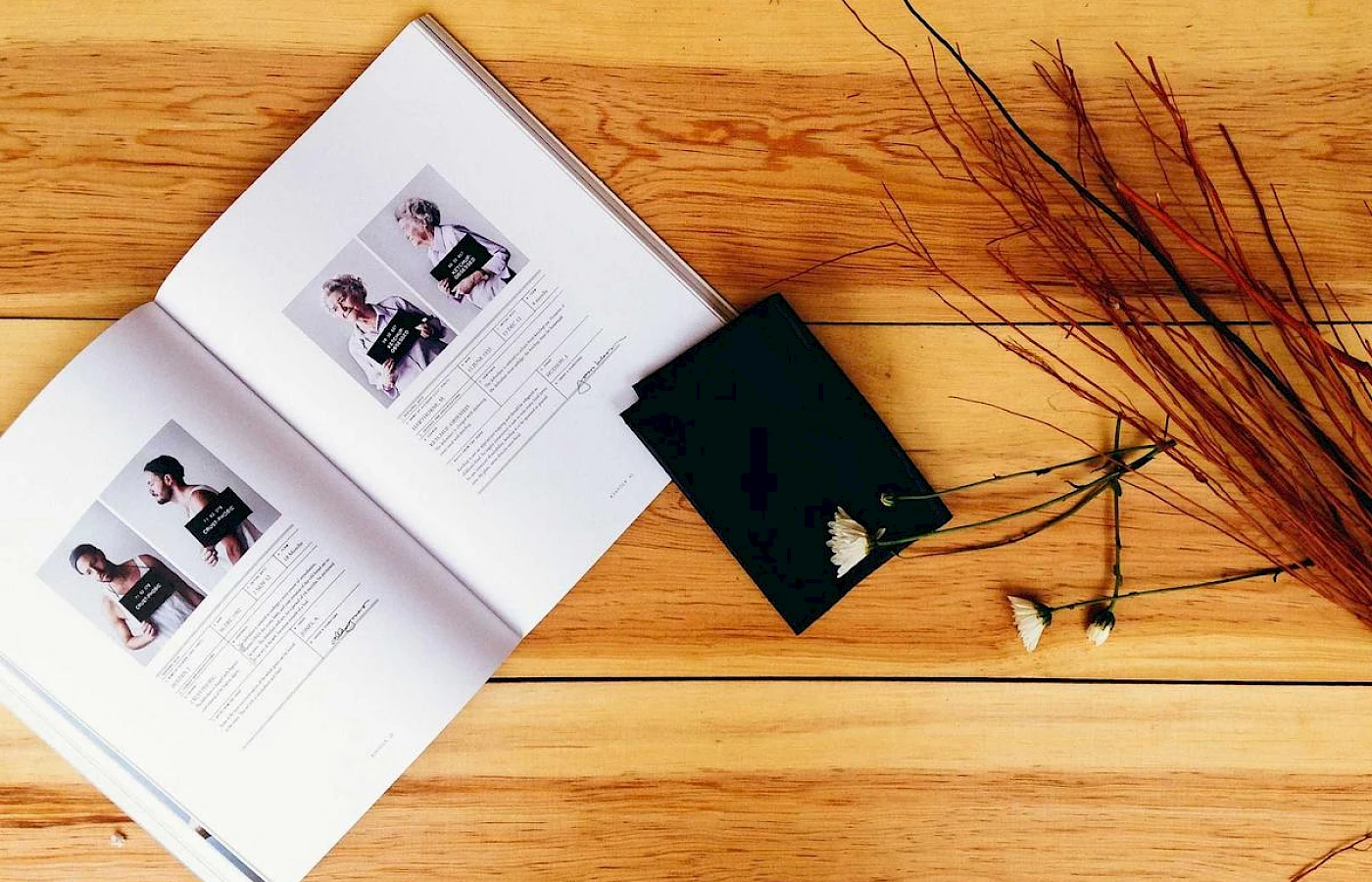 A book and flowers on a wooden table in a quiet guest room